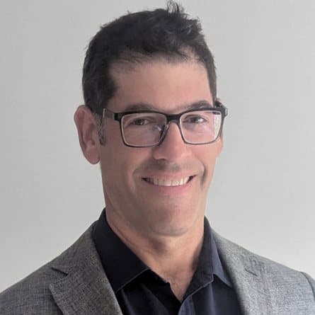 Scott Weinstein, smiling, in glasses and a grey jacket